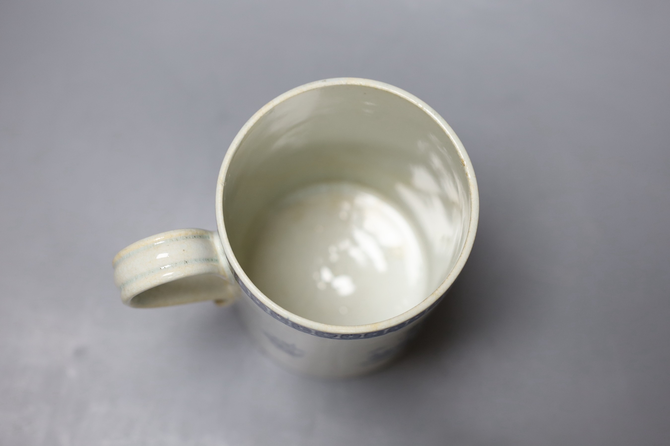 A Liverpool mug, decorated in blue underglaze with flowers and a cell border, 16cm